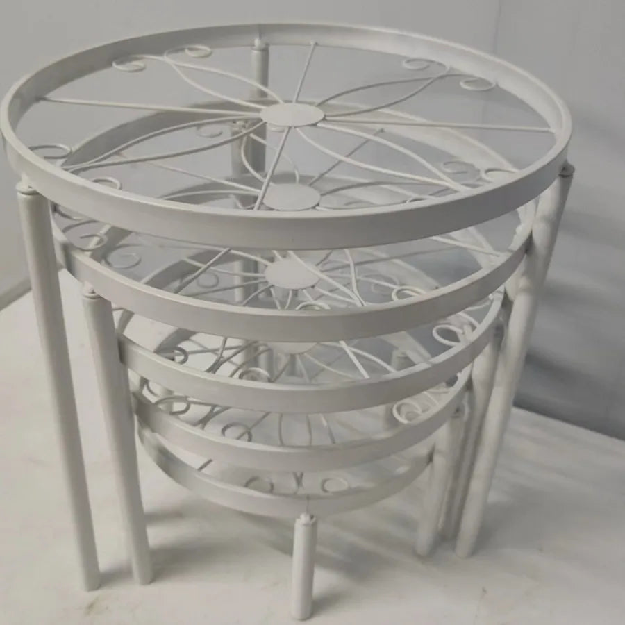 Decorative metal table with a circular design on a white floor.