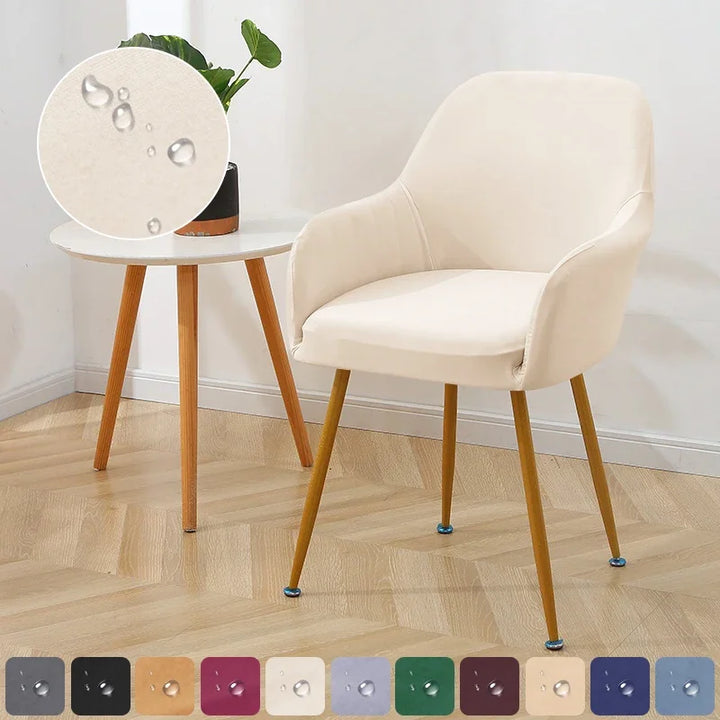 Beige chair with wooden legs in a room setting with a side table and plant.