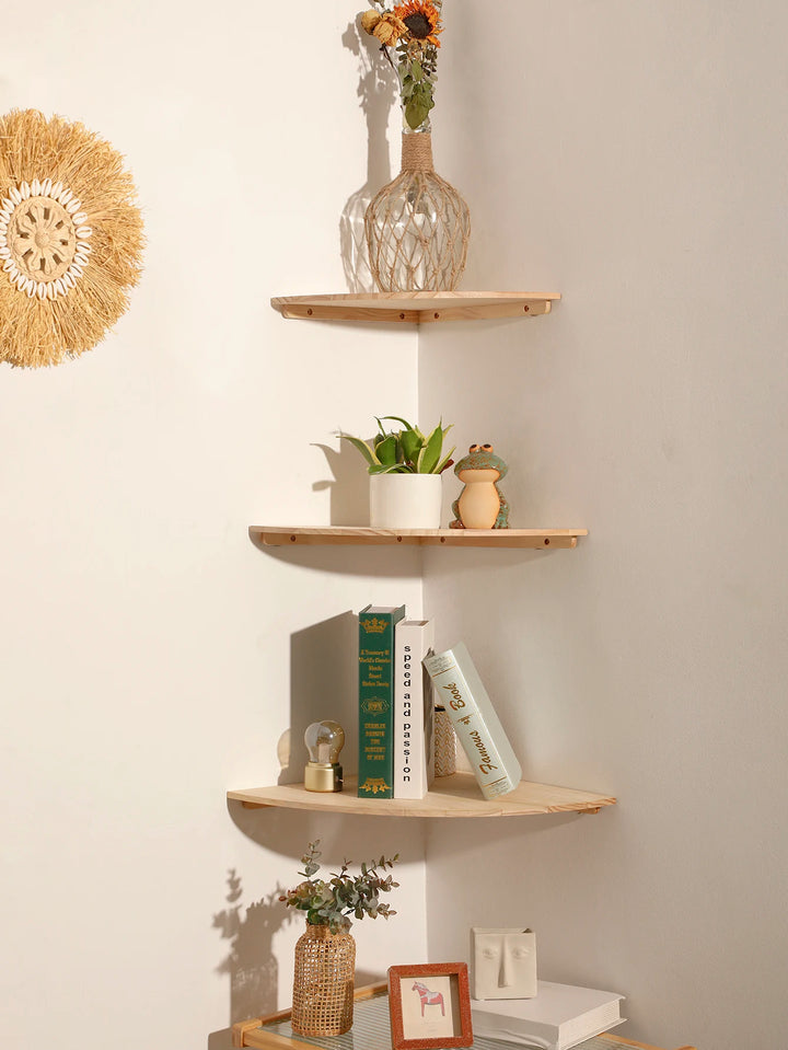Wooden corner shelves with decorative items against a beige wall.