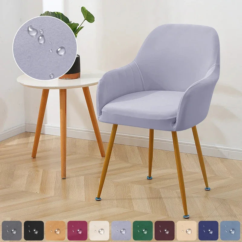 Light purple chair with wooden legs on a wooden floor, with a small round table and plant in the background.