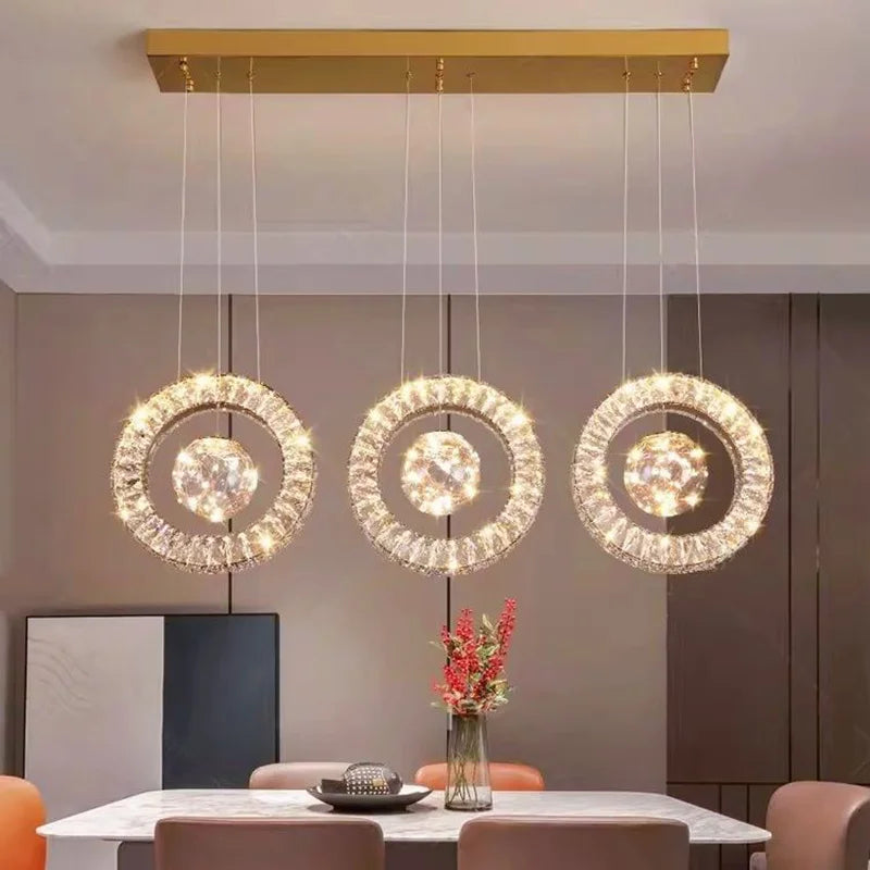 Modern chandelier with three circular lights in a dining room setting.