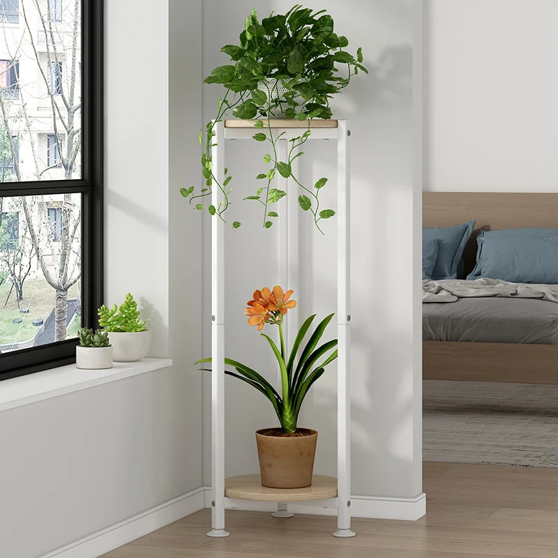 White plant stand with potted plants in a bedroom setting